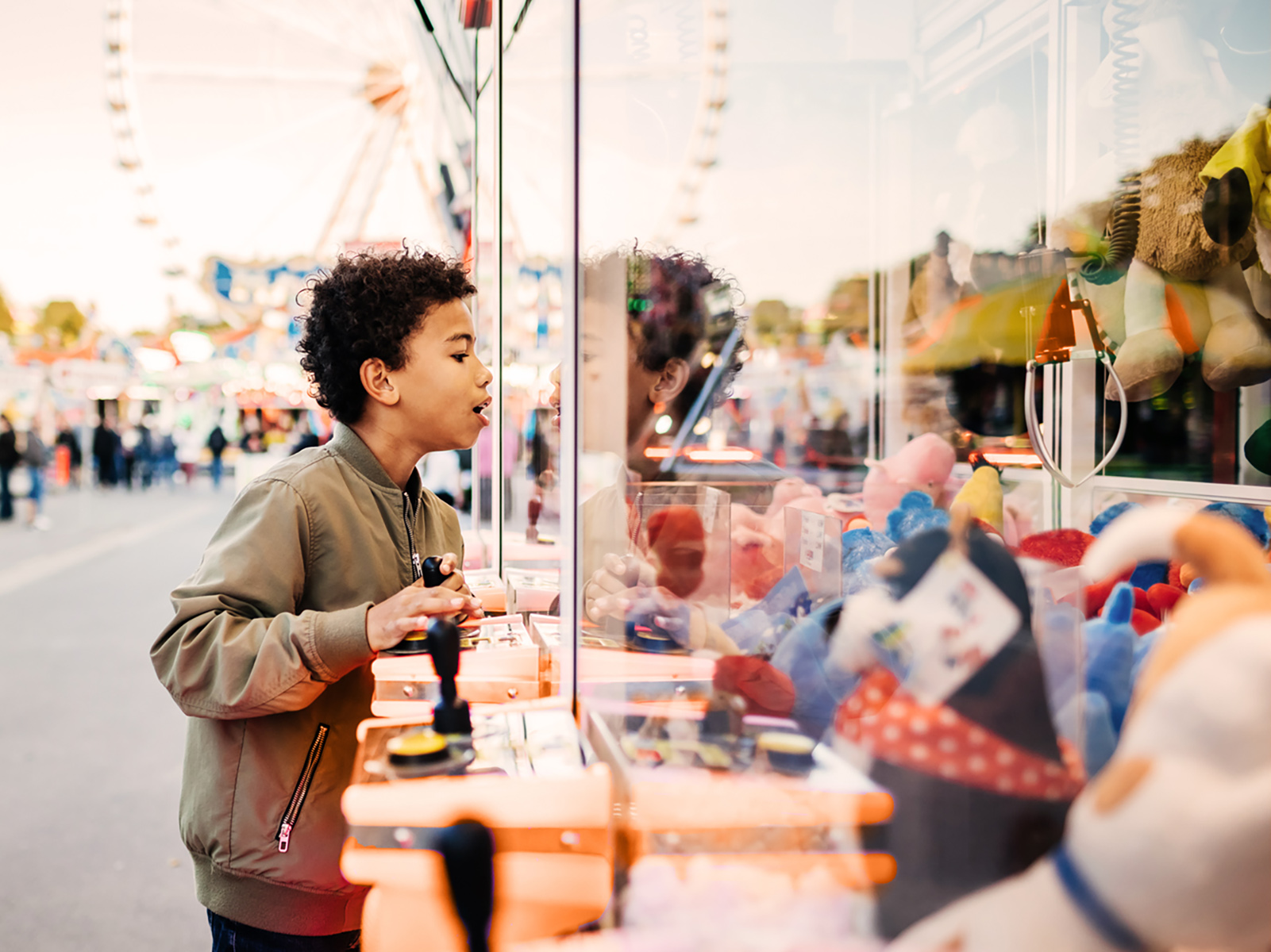 A boy looking at prizes at an amusement park.