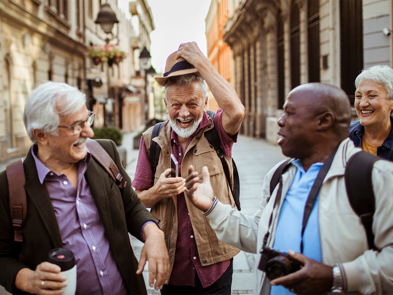 A group of five senior tourists laughing together while visiting a new city.