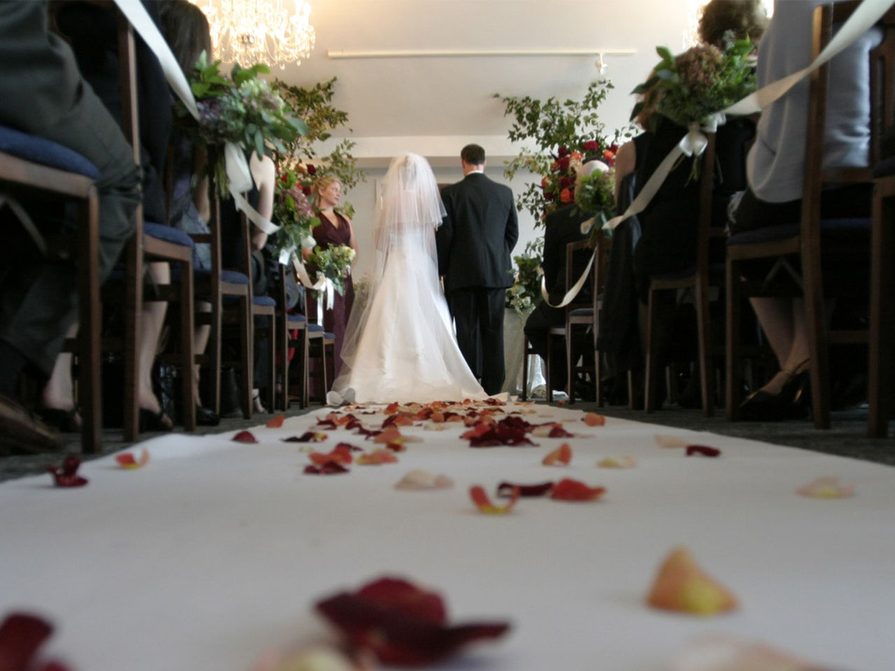 An engaged couple standing together at the end of the aisle during their wedding ceremony.